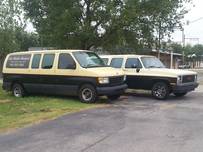 A yellow and green C&J Mobile Mechanic van parked beside a pickup truck